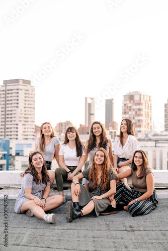 Big group of pretty girls smiling and having fun in a rooftop