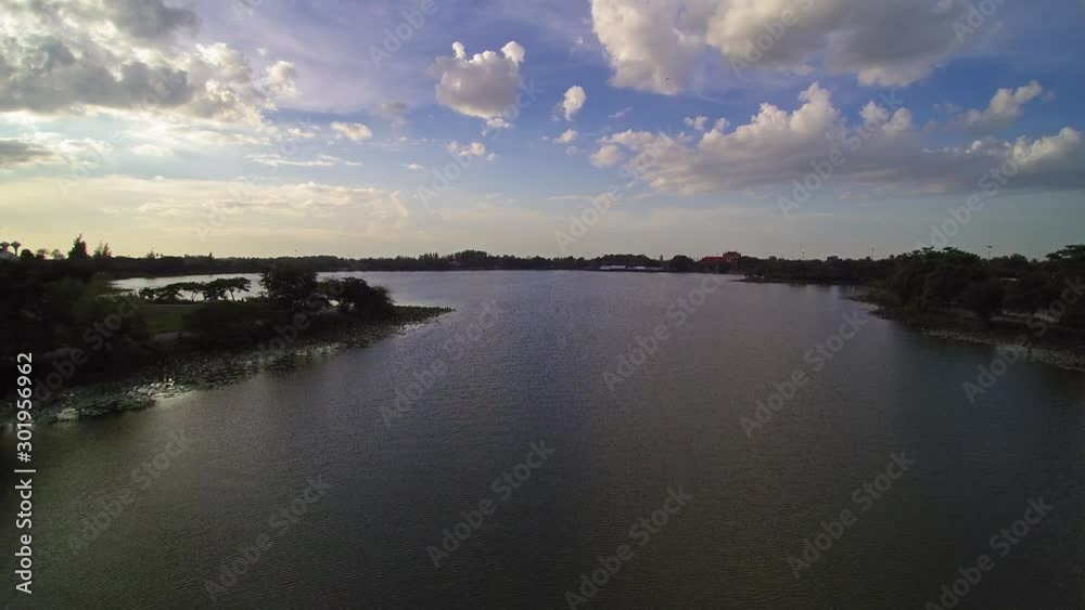 Vdo. Aerial view evening above reservoir around with green tree and yellow sun ling in cloudy sky background, sunset at Krajub reservoir, Nong Kob, Ban Pong, Ratchaburi, Thailand. Vdo. Aerial view evening above reservoir around with green tree and yellow sun ling in cloudy sky background, sunset at Krajub reservoir, Nong Kob, Ban Pong, Ratchaburi, Thailand.