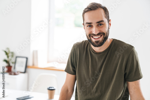 Image of young happy man looking and smiling at camera