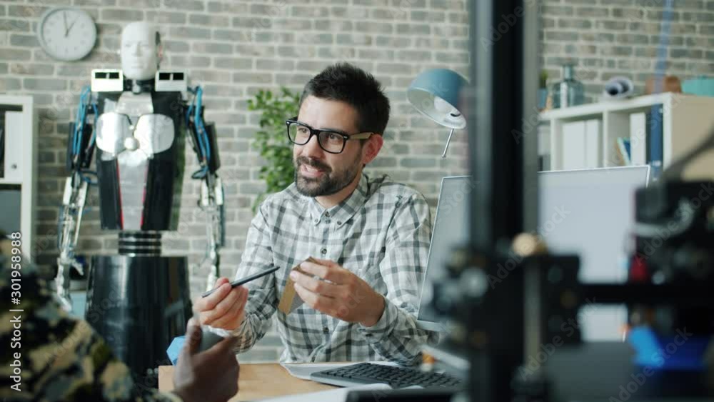 Creative guys colleagues are talking about 3d printed elements pointing at models in workplace sharing ideas about artificial intelligence. People and innovation concept.
