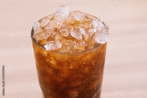 Iced honey lemon tea in glass background close up