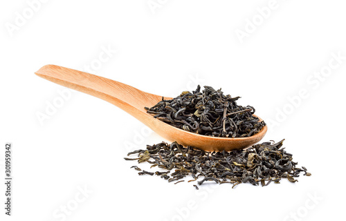 Dry green tea leaves in wood spoon on white background