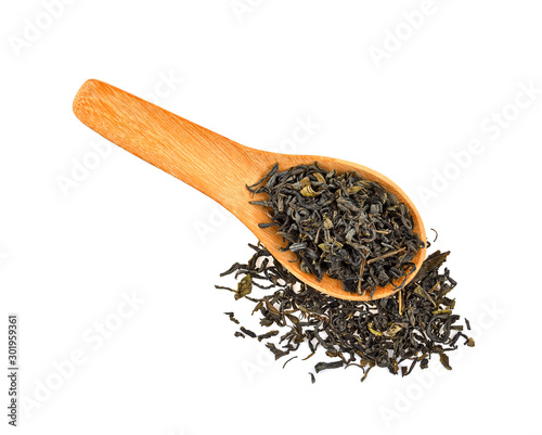 Dry green tea leaves in wood spoon on white background
