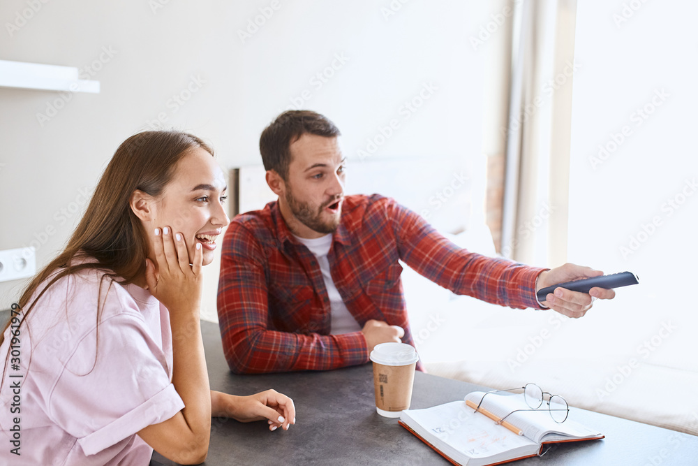 lovely excited couple watching tv, emotive man holding remote, choosing necessary chanel, sitting together with charming girlfriend, spending time at home, family concept