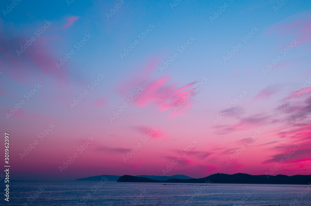Beautiful pink sunset on the sea with blue sky