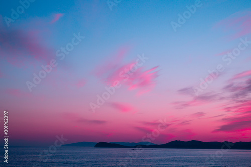 Beautiful pink sunset on the sea with blue sky © Ivan