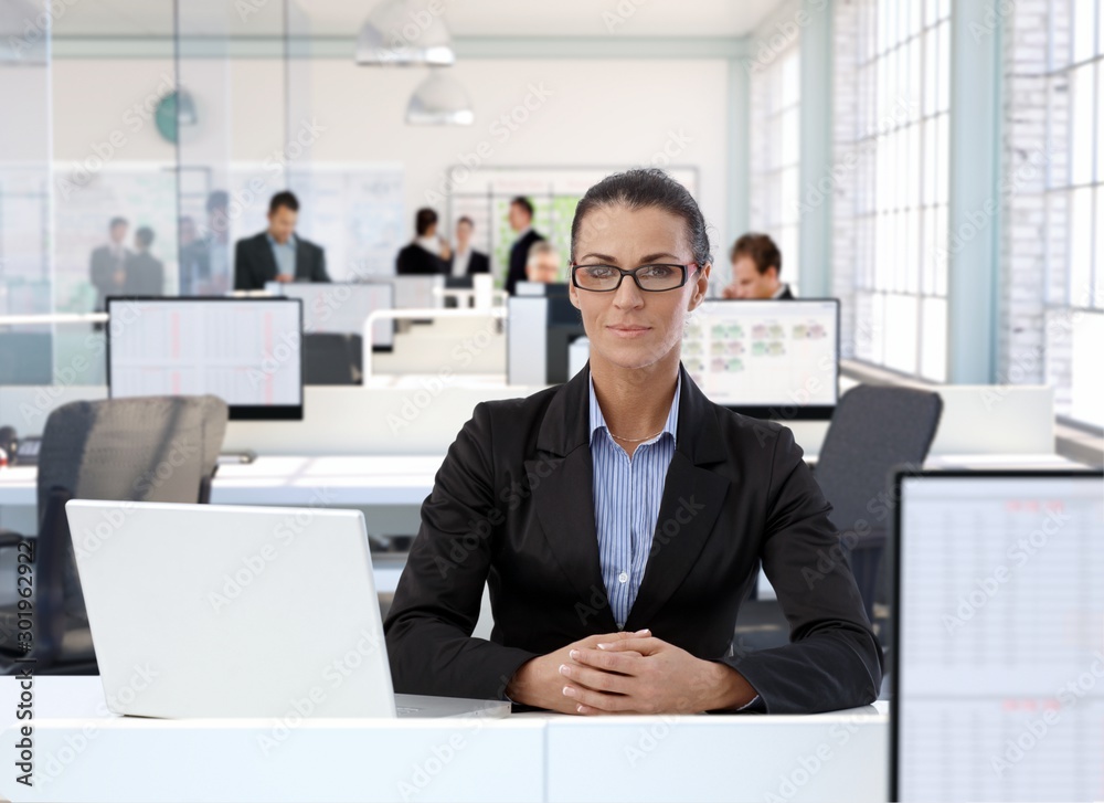 Mature businesswoman sitting at office desk Mature businesswoman sitting at office desk