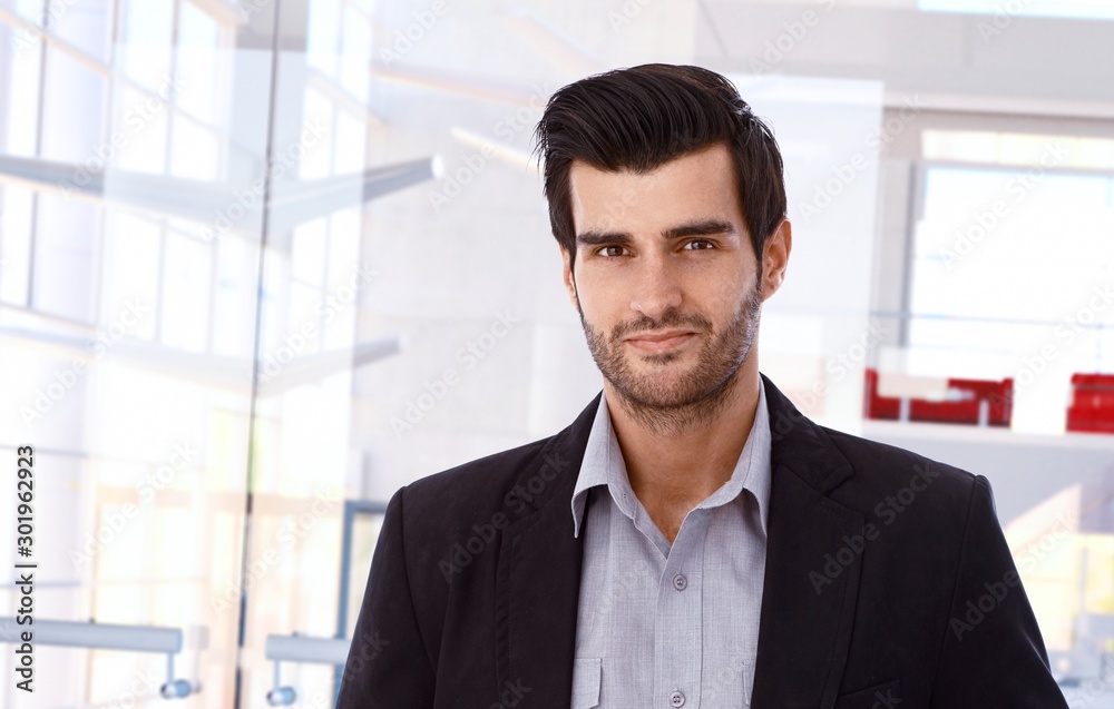 Smiling businessman in business interior Smiling businessman in business interior