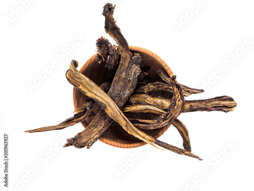 Symphytum root in wooden Cup on white background photo