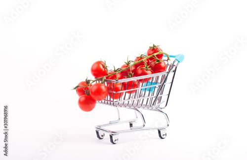 Classic shopping cart with small red tomatoes isolated on white background © Tetiana Kiselova