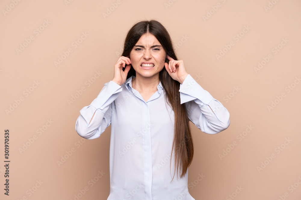 Young woman over isolated background frustrated and covering ears Young woman over isolated background frustrated and covering ears