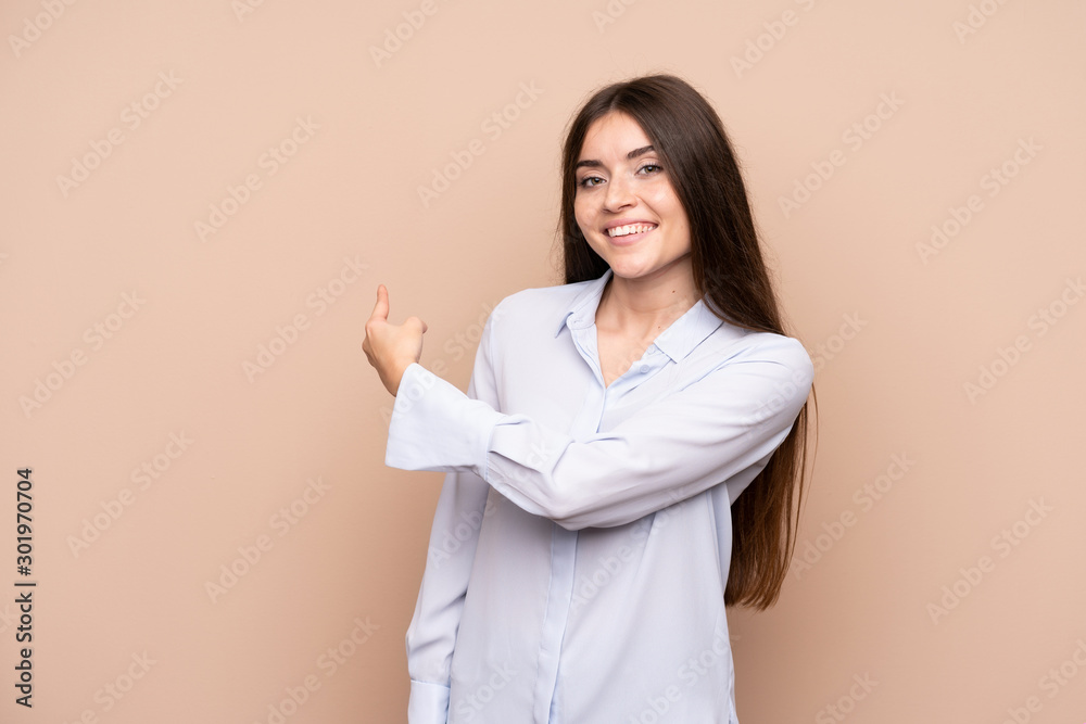Young woman over isolated background pointing back Young woman over isolated background pointing back