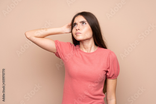 Young woman over isolated background having doubts and with confuse face expression