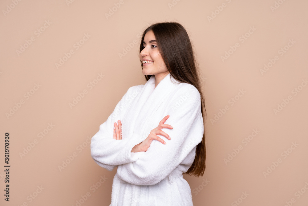 Young girl in a bathrobe over isolated background looking to the side Young girl in a bathrobe over isolated background looking to the side