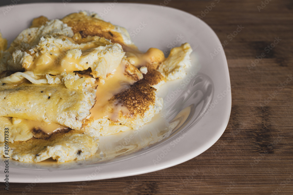 Juicy yellow omelet with melted cheese. Fried crust