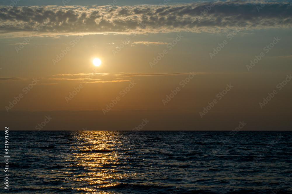 Bright yellow sun over the sea at dusk