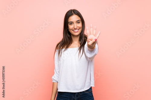Tela Young woman over isolated pink background happy and counting four with fingers