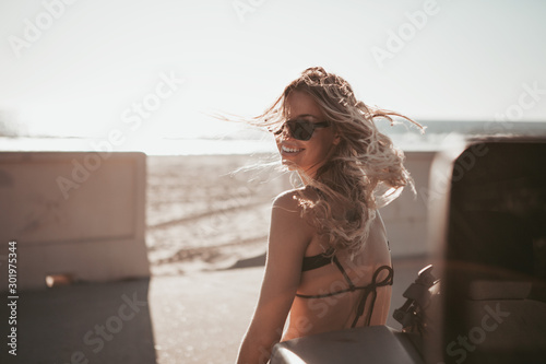 Fényképezés surfer girl standing by a car at the beach. california lifestyle