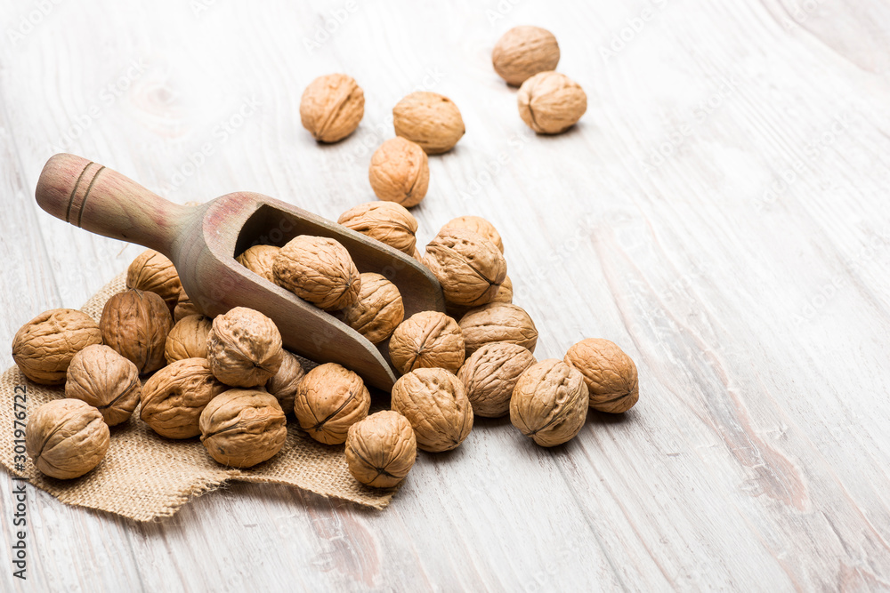 bunch of walnuts with wooden scoop on table bunch of walnuts with wooden scoop on table