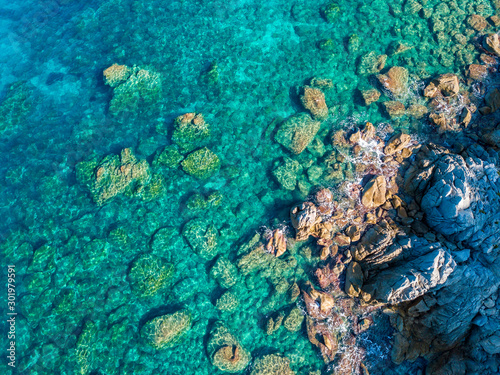 Aerial view of Tropea beach, crystal clear water and rocks that appear on the beach. Calabria, Italy. Swimmers, bathers floating on the water. Coastline of Calabria