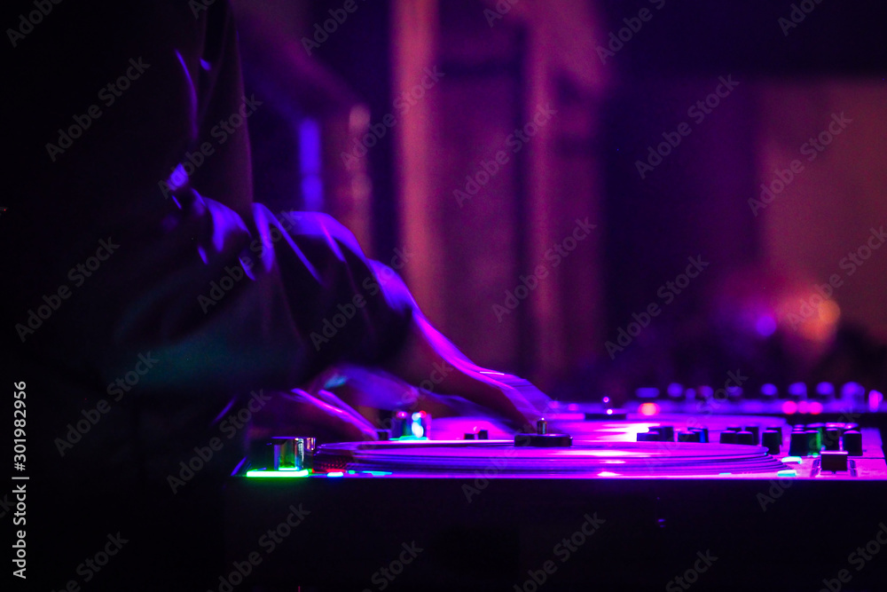 DJ is scratching vinyl record in disco nightclub DJ is scratching vinyl record in disco nightclub