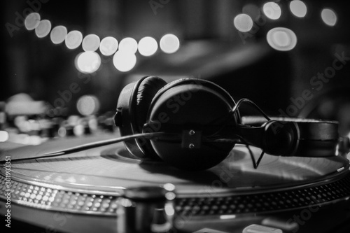 DJ headphones on a vinyl player in a dark nightclub, selective focus