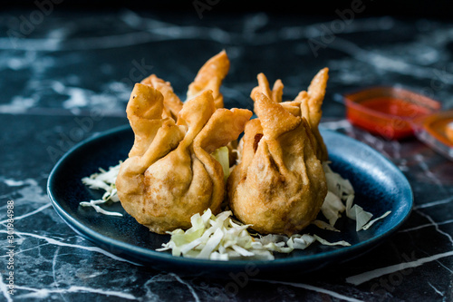 Nepalese Traditional Deep Fried Dumpling Momos served with Tomato Chutney, Schezwan sauce and Cabbage salad. photo