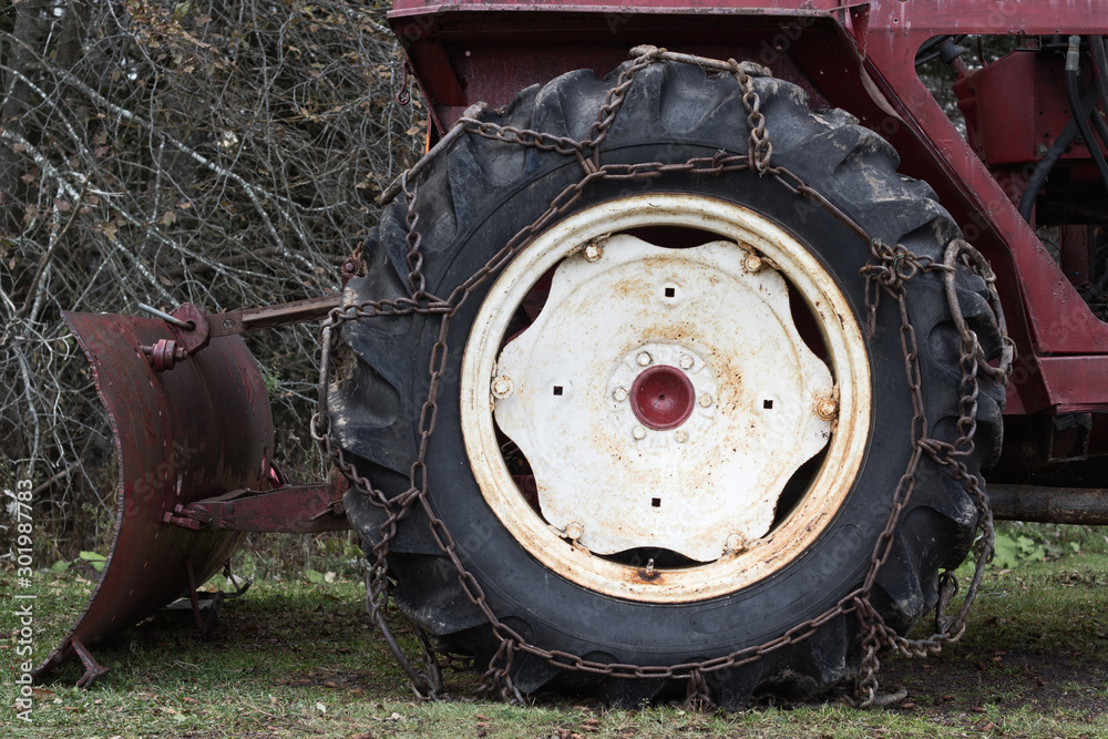 Old tractor tire and rear mounted plow ready for work Old tractor tire and rear mounted plow ready for work