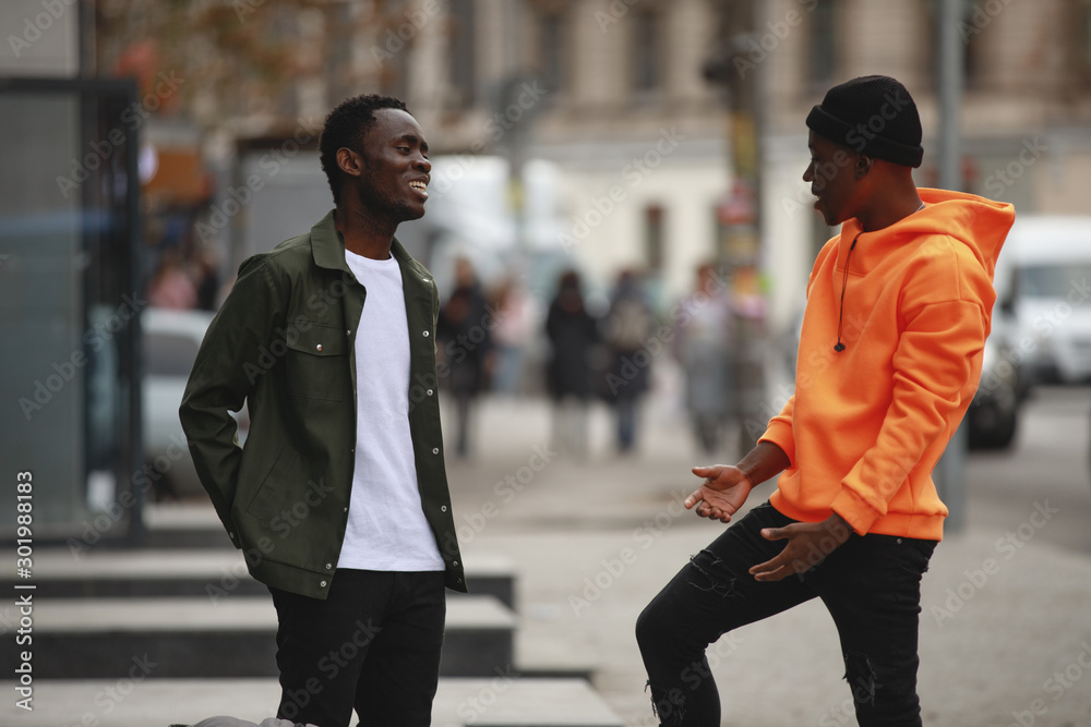 Handsome African men friends talking in city