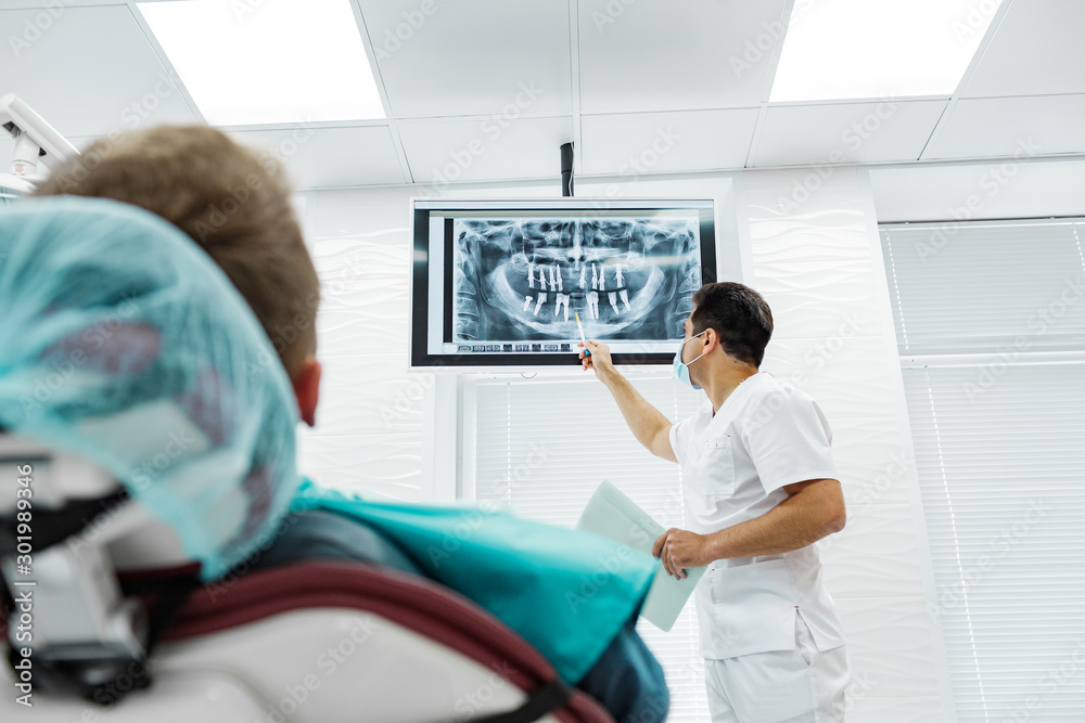 Obraz premium Cute young girl is being examined by the dentist