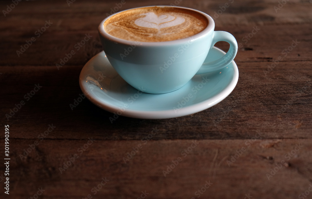 Cappuccino or latte with frothy foam, blue coffee cup top on wooden coffee shop background Cappuccino or latte with frothy foam, blue coffee cup top on wooden coffee shop background