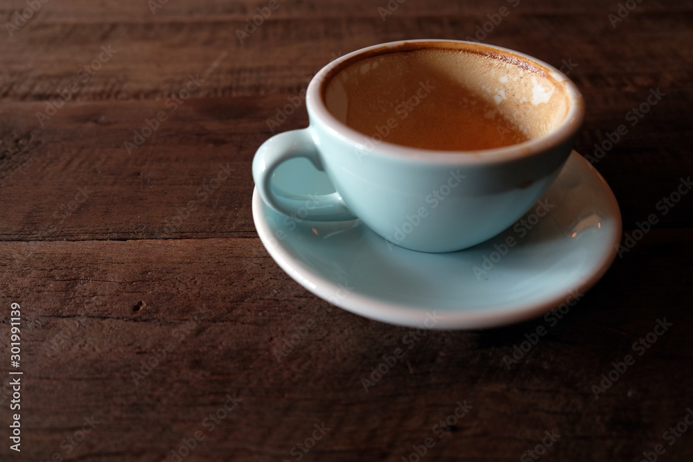Cappuccino or latte with frothy foam, blue coffee cup top on wooden coffee shop background Cappuccino or latte with frothy foam, blue coffee cup top on wooden coffee shop background