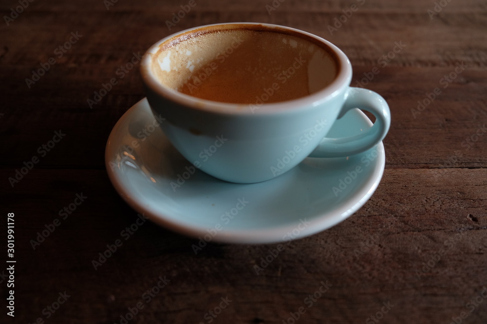 Cappuccino or latte with frothy foam, blue coffee cup top on wooden coffee shop background Cappuccino or latte with frothy foam, blue coffee cup top on wooden coffee shop background