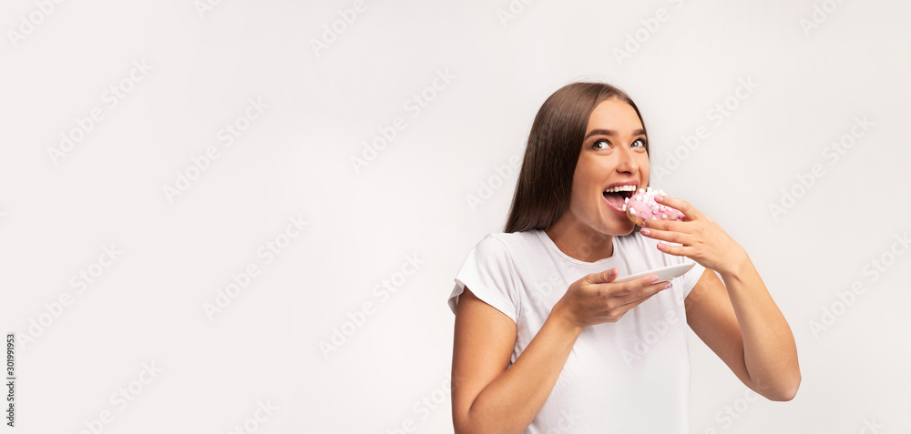 Pregnant Woman Eating Donut Standing On White Background, Panorama Pregnant Woman Eating Donut Standing On White Background, Panorama