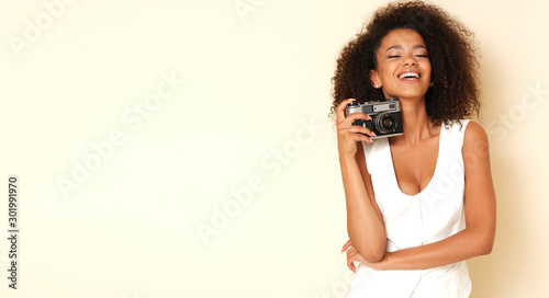 Happy, afro-american model with old-fashioned camera.