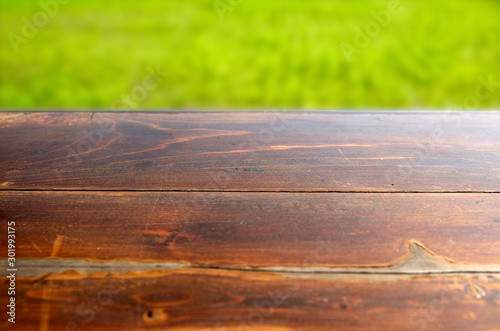 Empty wood table top on blur abstract green from garden in morning background. can be used for display or montage your products