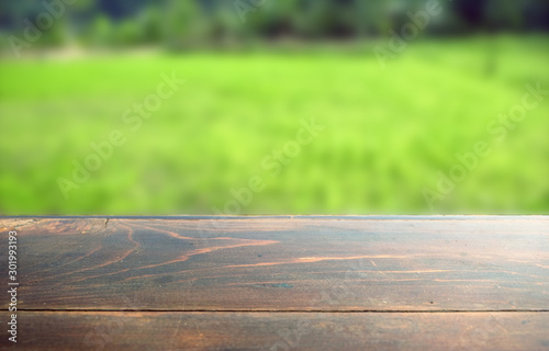 Empty wood table top on blur abstract green from garden in morning background. can be used for display or montage your products