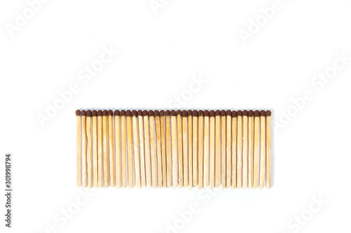 wooden matches lie in a row on a white background top view