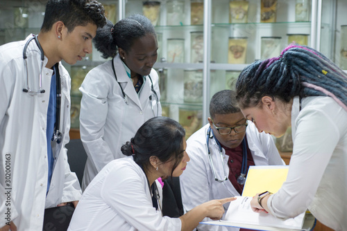 a group of young doctors  mixed race. Gathered at the conference  holding medical documents in their hands  discussing the topic.