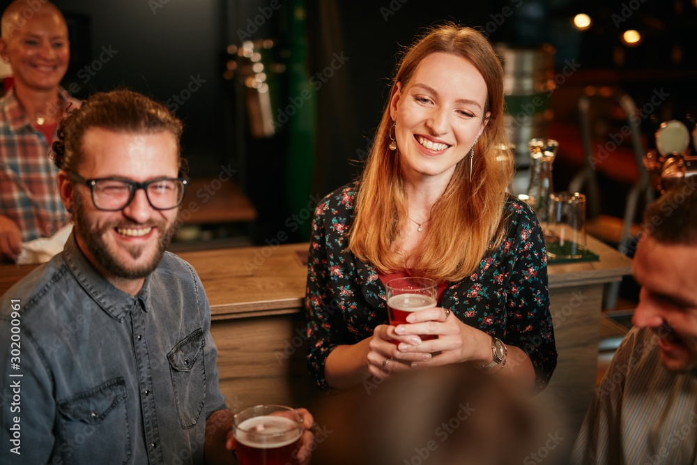 Group of friends drinking beer, chatting and having good time at pub. Night out. Group of friends drinking beer, chatting and having good time at pub. Night out.