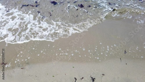 San Francisco, USA - August 2019: Waves washing over the beach on a summer day