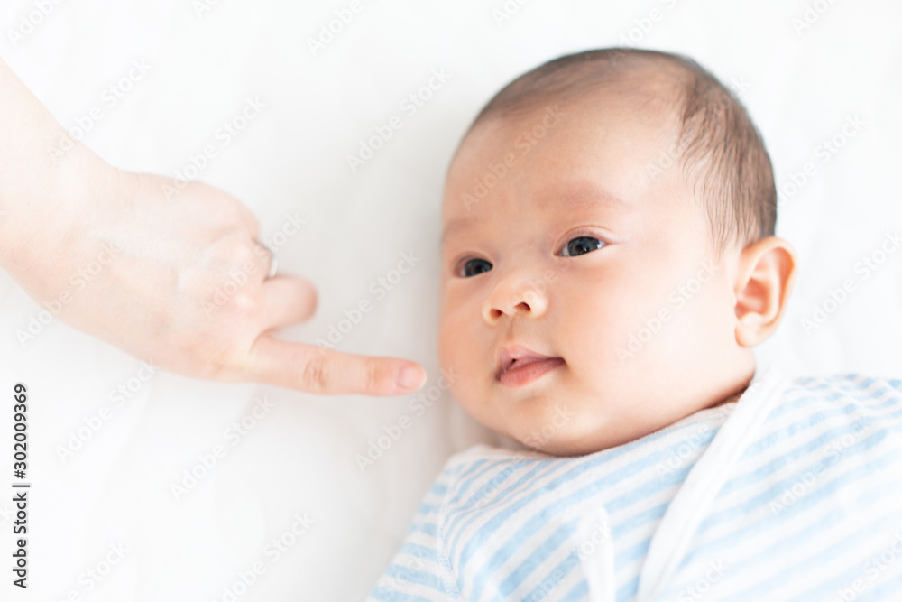 赤ちゃんの顔に触れる女性
