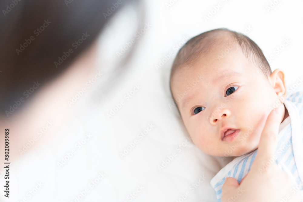 赤ちゃんの顔に触れる女性 赤ちゃんの顔に触れる女性
