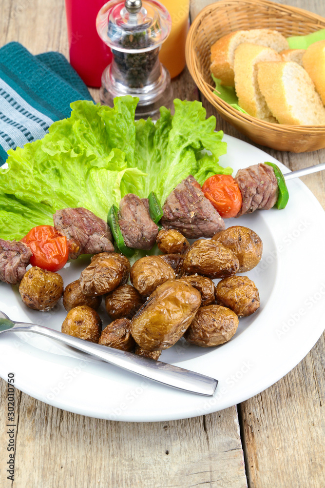grilled potatoes and beef skewer on a plate grilled potatoes and beef skewer on a plate