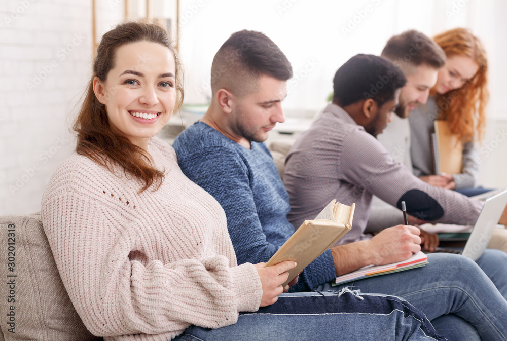 Happy student girl reading book, preparing for exam Happy student girl reading book, preparing for exam