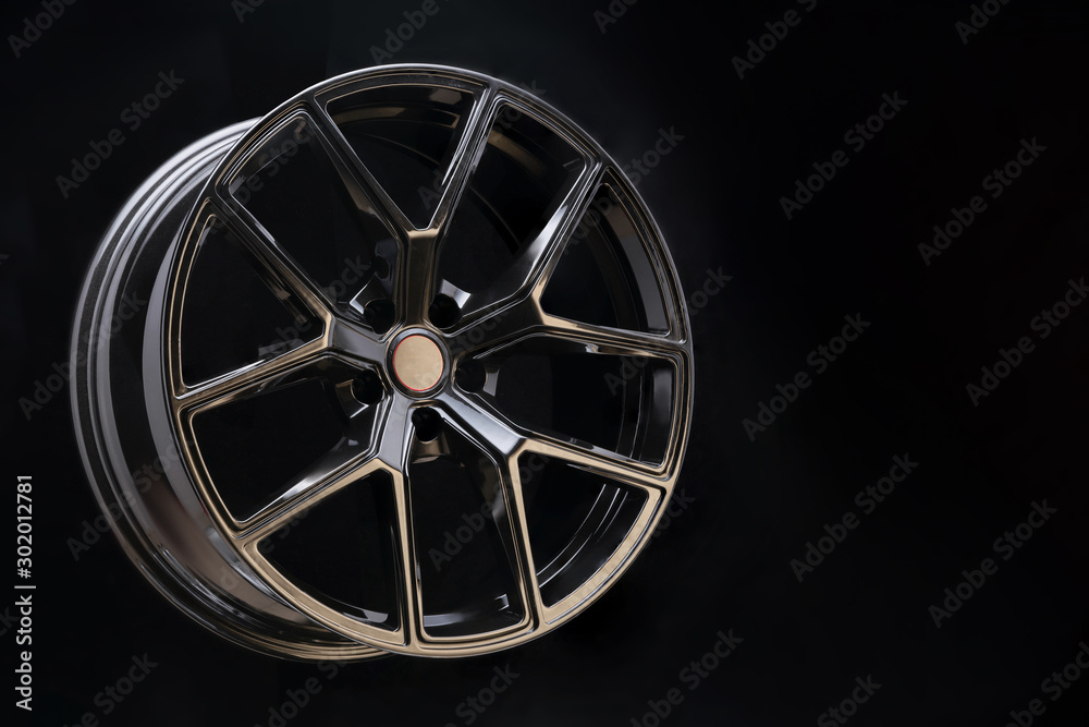 beautiful and cool aluminum forged wheel, close-up. dark on black background, copyspace. sports style for auto racing and auto tuning, lightweight and durable.