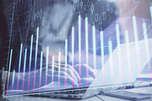 Double exposure of market chart with man working on computer on background. Concept of financial analysis. © peshkova