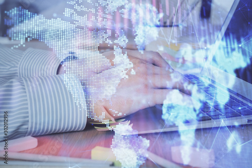 Multi exposure of stock market graph with man working on laptop on background. Concept of financial analysis.