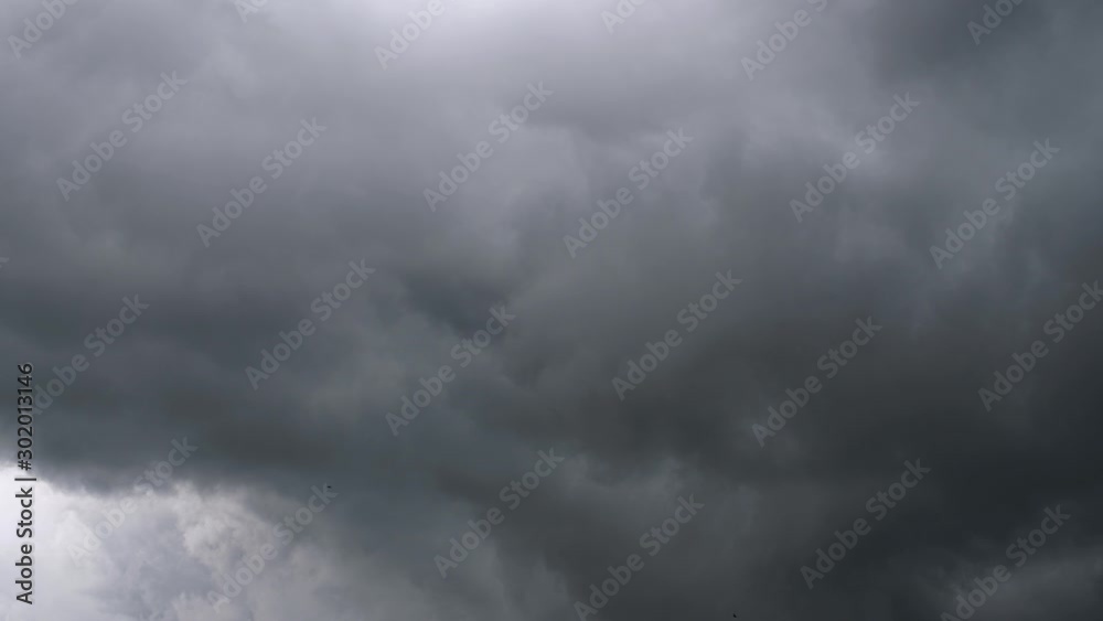 Dark storm clouds brew in the dark, ominous sky    