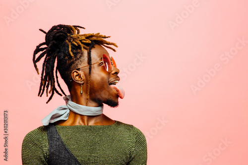 Photo Fun studio profile portrait of trendy young man with sunglasses and  tongue out